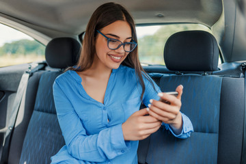 Businesswoman Using Smart Phone Car Inside