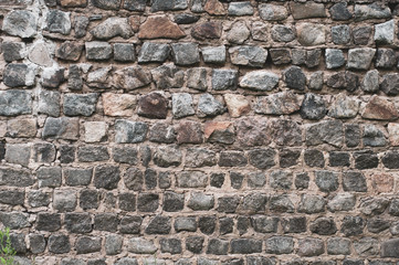 Fototapeta premium The old weathered wall of granite lined rough stone