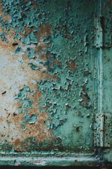 green cracked bare paint close up on a vertical wooden surface