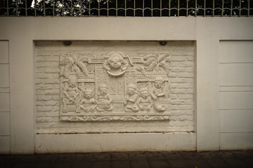 Beautiful white Java stucco patterned on the boundary wall. Vintage white wall bas-relief stucco in plaster, depicts Lotus flowers background.