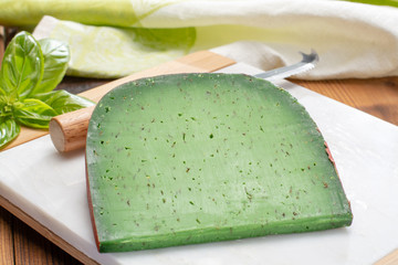 Cheese collection, piece of Dutch green pesto hard cheese with fresh basil
