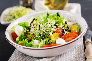 Vegetarian salad with cherry tomato, mozzarella and lettuce. Italian cuisine.