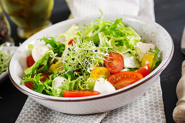 Vegetarian salad with cherry tomato, mozzarella and lettuce. Italian cuisine.