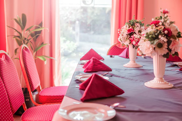 Restaurant table with red napkins and flowers