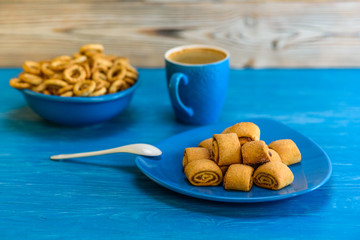 Small and very dry bagels in a blue bowl photographed on a vintage wooden background.