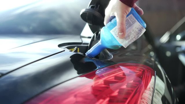 Pouring Fuel Additive Into Gas Tank For Extra Mileage.