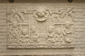 Fototapeta na wymiar Beautiful white Java stucco patterned on the boundary wall. Vintage white wall bas-relief stucco in plaster, depicts Lotus flowers background.