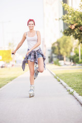 Young woman with rollerblades listening to a music outdoors
