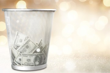 Money in thash bin on wooden floor