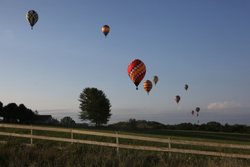 Hot air balloons flying over rural Iowa landscape