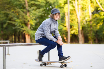 Young sporty girl riding on longboard in park.