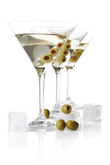 Cold classic dry martini with olives & ice cubes on white in a line