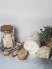 Zero waste concept. Eco-friendly bath set. Brushes, soap in jar, towel, pumice and bast and plant...