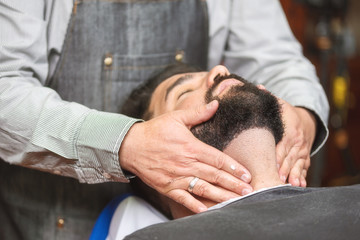 Obraz premium Hair stylist applying after shaving lotion at barber shop .