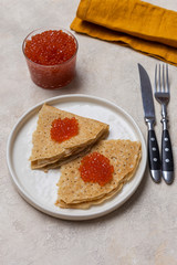 Close up fresh blini with red caviar on white background