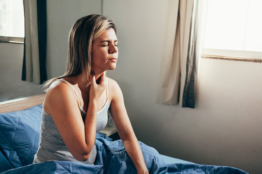 Young Woman Suffering From Sore Throat In Bed