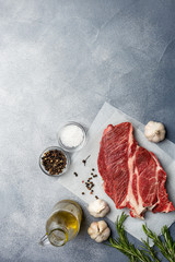 Fresh meat with ingredients at gray background