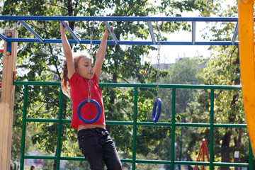 A girl climbs the stairs on the playground in the park