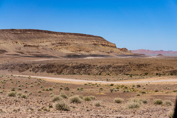gravel road with tire trace and mountain namibia