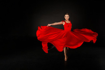 Young beautiful girl in red waving flying dress
