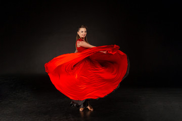 Beautiful young girl dancing. The girl with flying red dress.