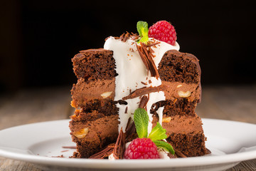 A piece of chocolate cream with cream and raspberries