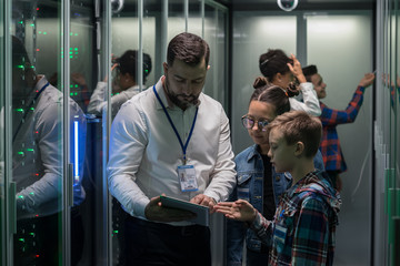 IT technician showing tablet to children