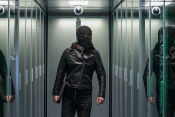 Masked hacker walking through rows of servers