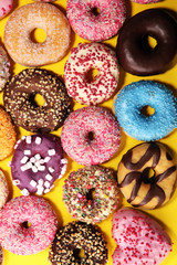 assorted donuts with chocolate frosted, pink glazed and sprinkles donuts