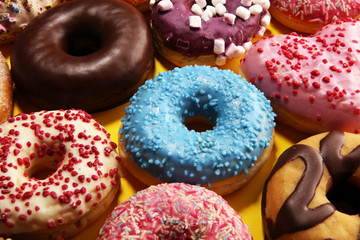 assorted donuts with chocolate frosted, pink glazed and sprinkles donuts