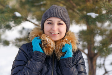 Winter young woman portrait. Beauty Joyful Model Girl laughing and having fun in winter park. Beautiful young female outdoors