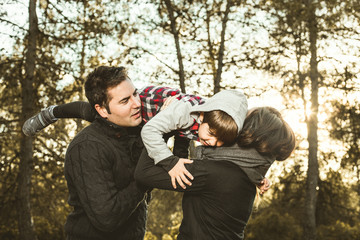 Happy family playing in the countryside. Child on his father's shoulders
