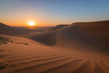 Fototapeta na wymiar Sunset in the desert with beautiful sand dunes.