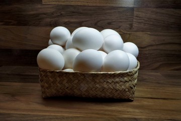 A full basket of white chicken eggs.