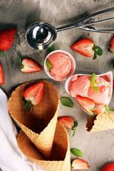 Strawberry ice cream scoop with fresh strawberries and icecream cones