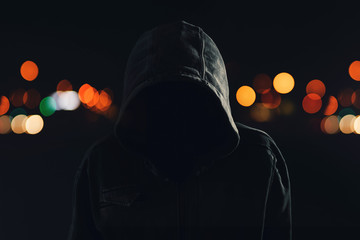 Hooligan with hoodie and obscured face at night - obrazy, fototapety, plakaty