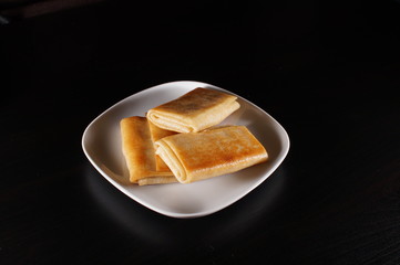 pancakes on white plate on black