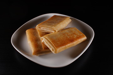 pancakes on white plate on black