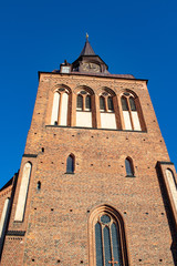 View up a big chirch steeple in front of blue sky 