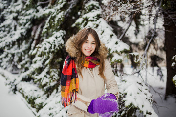 Fototapeta na wymiar Beautiful young Caucasian people have the joy of happiness and fun in the winter in a snowy forest. Sculpt to make hands snowball gloves