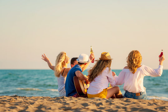 Group of friends on the beach play