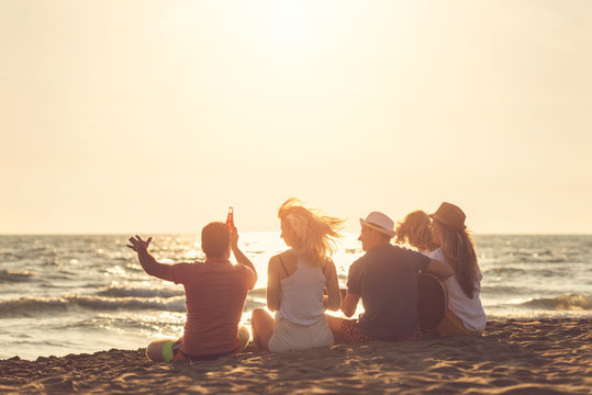 Group of friends on the beach play