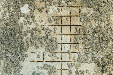 Surface of damaged reinforced plaster with exposed rusty steel construction grid