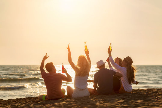 Group of friends on the beach play