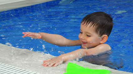 Fototapeta na wymiar Happy little boy in swimming pool