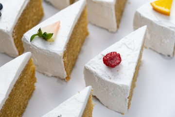 Delicious creamy minimal white cake with fruit on white background.