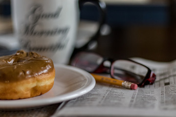 Obraz na płótnie Canvas donut and crossword puzzle for breakfast