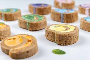 Delicious creamy colourful minimal cake roll on white background.