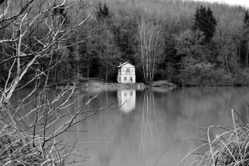 Haus am Ellertshäuser See mit Spiegelung im Wasser in schwarz-weiß, bei Stadtlauringen, Schweinfurt, Franken, Bayern, Deutschland