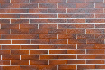 Wall of bricks made of floor tiles, in different brown and orange hues, can be used as background